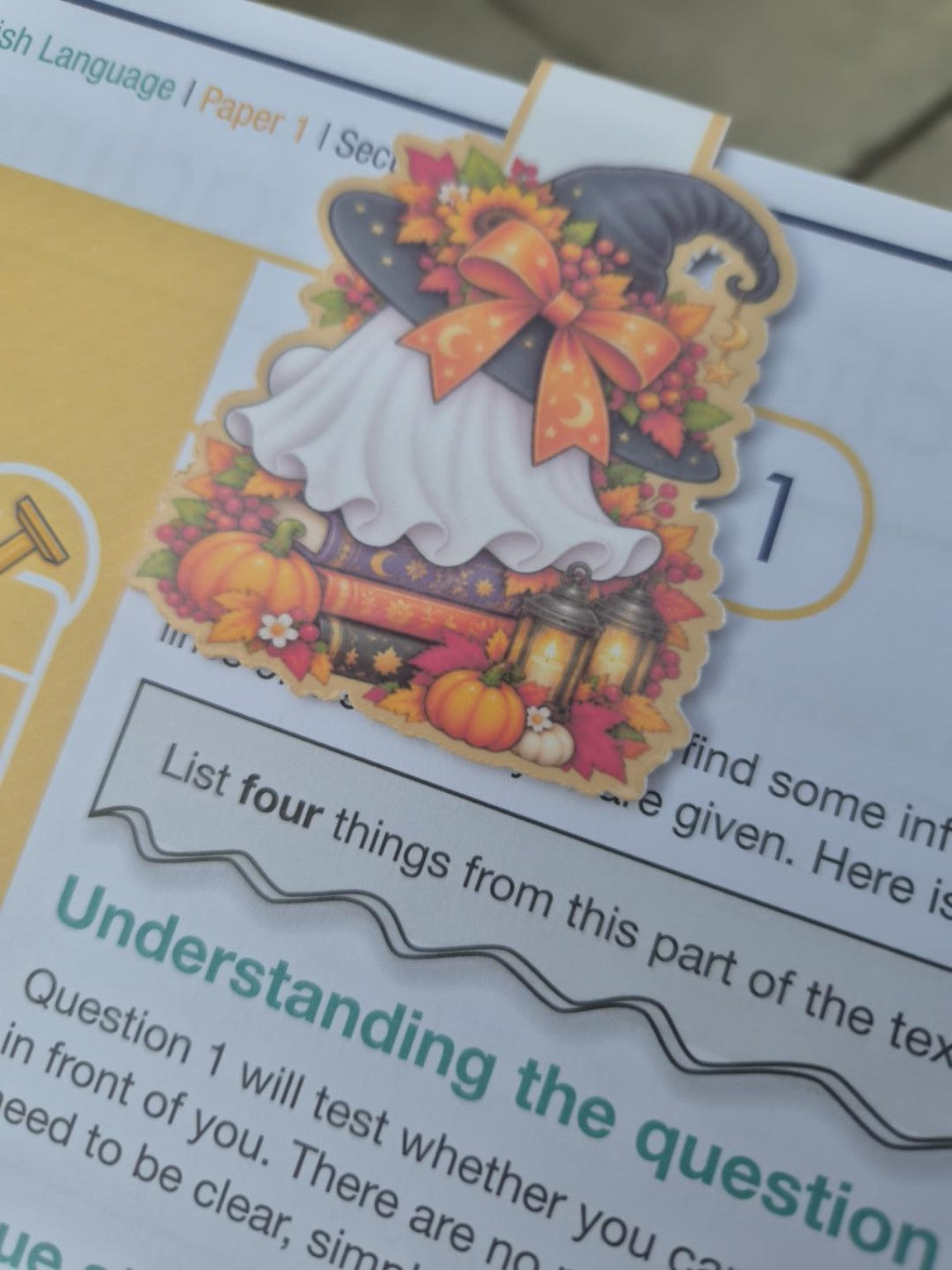Back of Halloween ghost magnetic bookmark with witch hat, pumpkins, books and lanterns